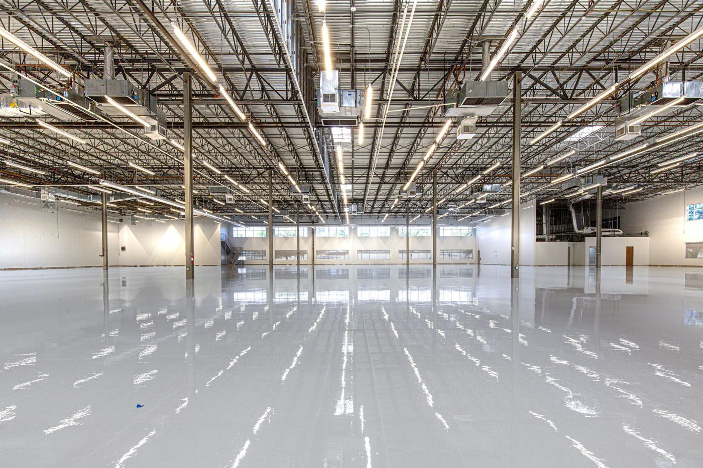 Glossy epoxy-coated concrete floor reflecting overhead lights