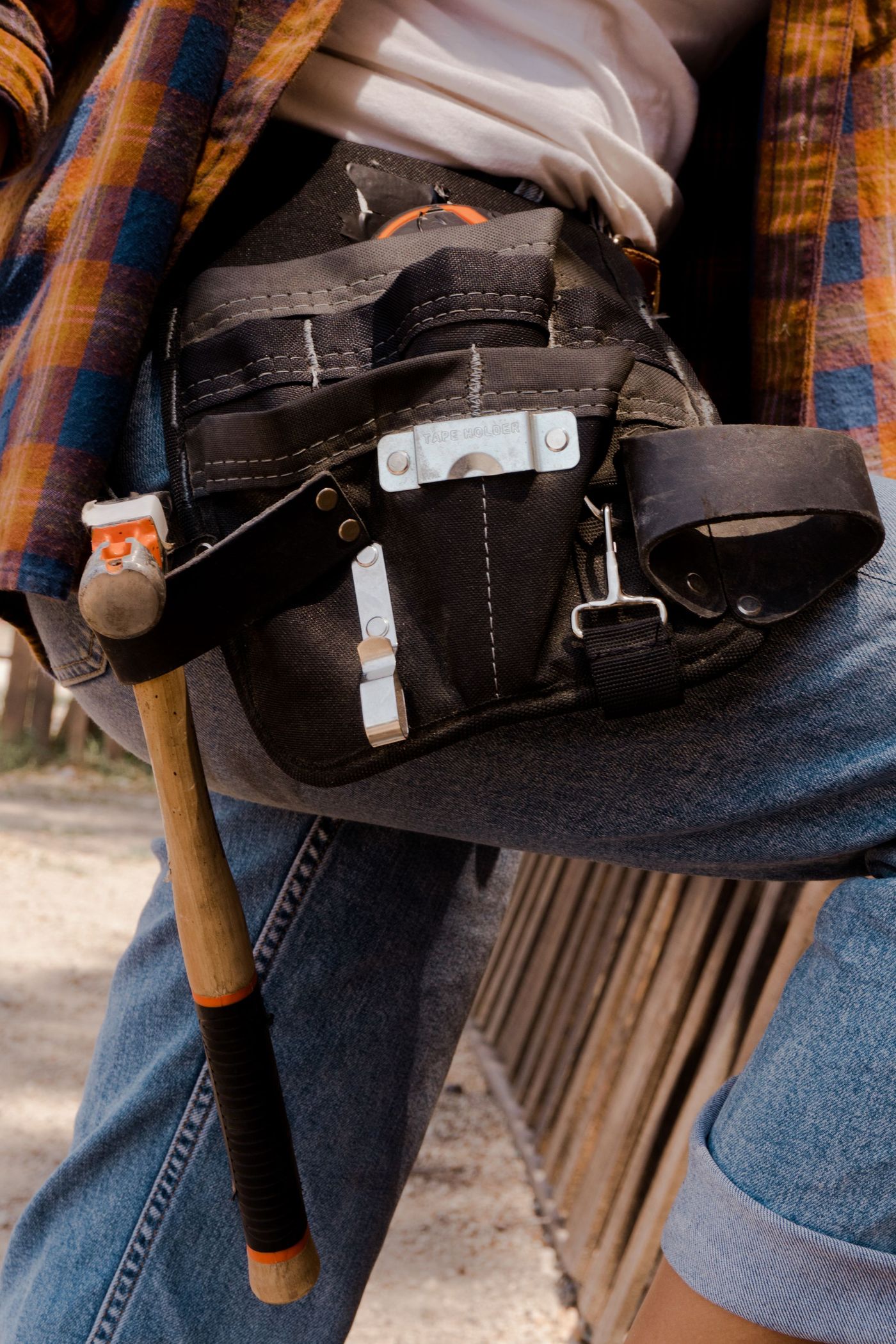 Close-up of a leather tool belt loaded with hand tools
