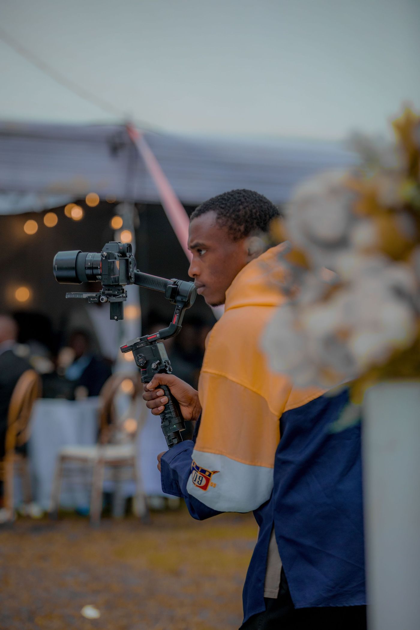 Videographer holding a camera on a gimbal outdoors